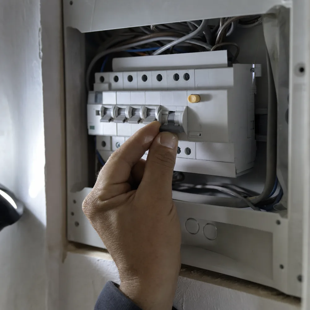 Mano subiendo los magnetotérmicos siguiendo las indicaciones del electricista urgente en Mallorca